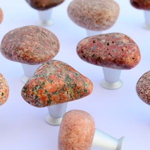 May include: A set of 11 stone knobs with silver bases. The knobs are made of natural stone with a variety of colours and patterns. They are perfect for adding a unique touch to any home decor.