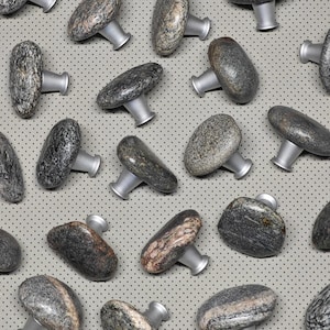 Könnte beinhalten: Eine Sammlung von 20 naturfarbenen Steinknaufgriffen mit silberner Metallbeschläge. Die Knäufe sind in verschiedenen Grautönen und Brauntönen mit einzigartigen Mustern gehalten.