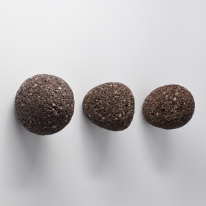 White stone round hook with brass fitting installed on a bathroom wall. The elegant simplicity of the stone contrasts beautifully with the sturdy brass screw, providing a functional and aesthetically pleasing addition to any modern or rustic bathroom. Ideal for hanging towels, robes, or other small accessories with ease