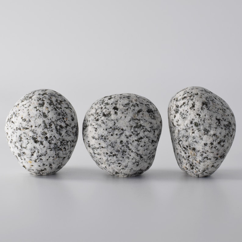 A beautiful collection of round stone hooks in different colors—brown, grey, and white—mounted on various types of furniture and walls. These hooks, with their brass fittings, effortlessly add a touch of elegance and rustic charm to any space, providing both form and function for your home organization needs