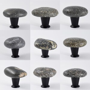 Artisan-crafted rock knobs on a sideboard, emphasizing irregular shapes and smooth, polished finishes. These handmade beach stone drawer pulls are ideal for cabinets, storage units, or nightstands, adding tactile and visual appeal while enhancing interior design with coastal elegance, rustic charm, and natural, one-of-a-kind beauty.
