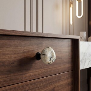 Handmade beach stone knobs on a rustic dresser, showing natural pebble textures and smooth surfaces. Ideal for drawers, cupboards, and storage furniture, these unique stone pulls add tactile charm and coastal-inspired elegance to bedrooms, living rooms, or kitchens, combining organic beauty with functional, handcrafted hardware for a one-of-a-kind home accent.