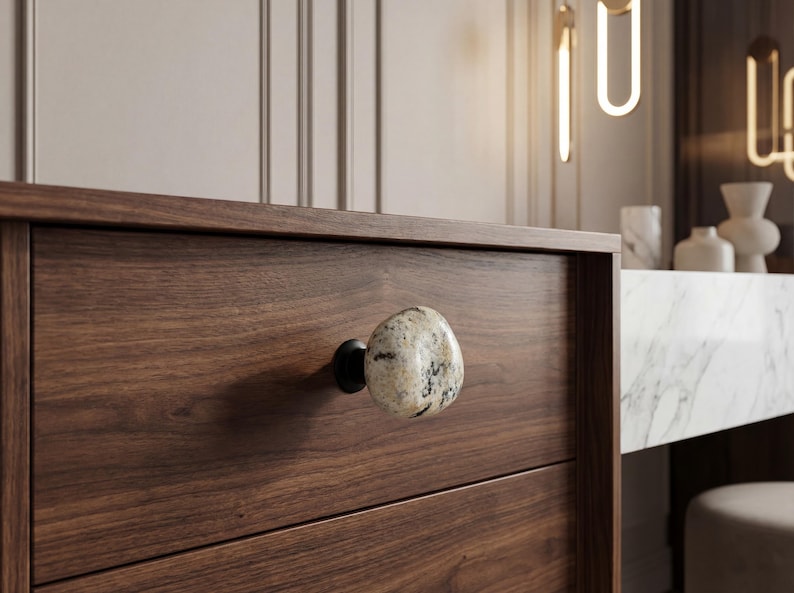 Handmade beach stone knobs on a rustic dresser, showing natural pebble textures and smooth surfaces. Ideal for drawers, cupboards, and storage furniture, these unique stone pulls add tactile charm and coastal-inspired elegance to bedrooms, living rooms, or kitchens, combining organic beauty with functional, handcrafted hardware for a one-of-a-kind home accent.