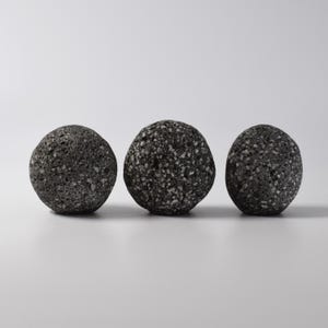 Close-up of a grey stone knob being installed into a wooden cabinet door with a brass threaded fitting. The deep drilled stone and precision threading ensure a secure, tight fit, making it easy to add a touch of nature to your home decor. This simple yet stylish stone knob is perfect for use as a hook or drawer pull