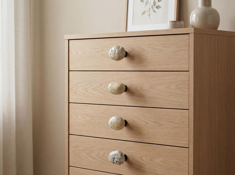 pebble drawer pulls on a modern kitchen cabinet, highlighting the irregular shapes and earthy tones. These beach stone handles bring a natural, tactile touch to drawers, sideboards, and cupboards, perfect for Scandinavian, farmhouse, or bohemian interiors seeking subtle coastal charm and durable, handcrafted furniture hardware.