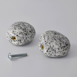 Natural stone hooks in brown, grey, and white, each showcasing its deep drilled stone design and brass threaded fitting. These versatile stone hooks are perfect for hanging coats, keys, or jewelry, adding a rustic yet modern feel to any entryway, bedroom, or living area. Knobs, handles or pulls.