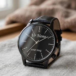May include: Black wristwatch with a leather band. The watch face is black with white numerals and hands. The text "Ur Name" and "your msg" are printed on the watch face.