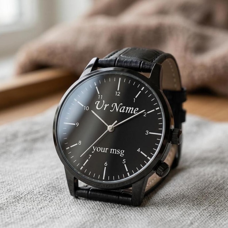 May include: Black wristwatch with a leather band. The watch face is black with white numerals and hands. The text "Ur Name" and "your msg" are printed on the watch face.