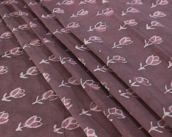May include: A close-up of a mauve fabric with a white floral print. The fabric has a subtle sheen and a soft texture.