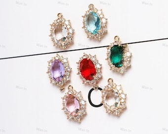 May include: Seven oval-shaped jewelry charms featuring a central colored gemstone surrounded by a halo of small clear crystals. The charms come in clear, light blue, purple, red, dark green, and light pink, each with a small metal loop at the top.
