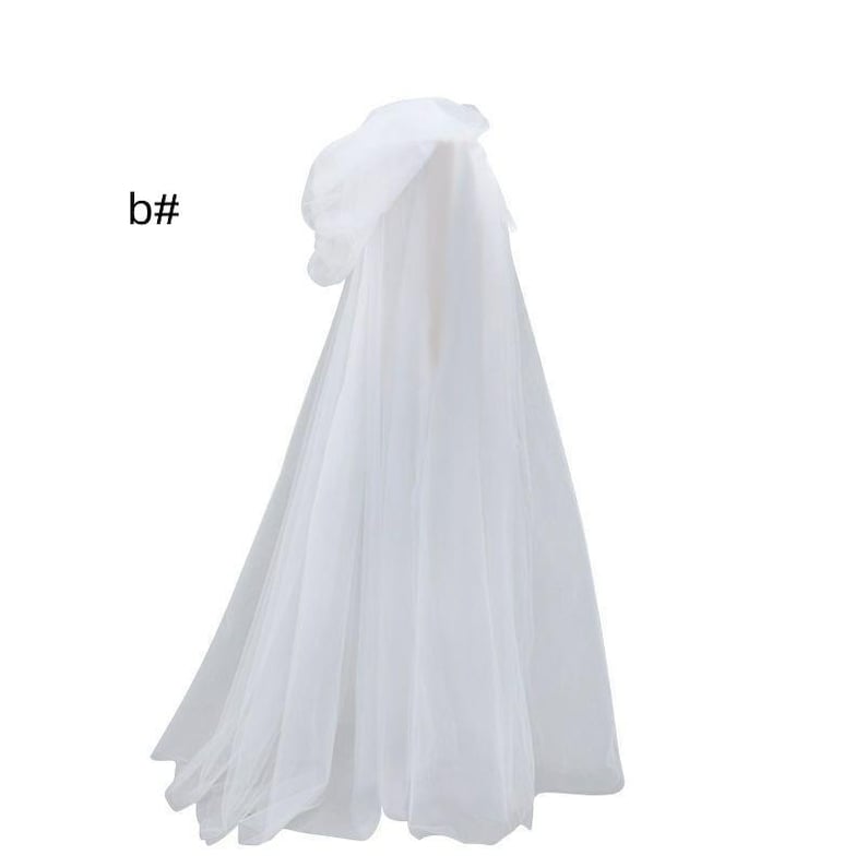 Puede incluir: Una capa con capucha blanca hecha de tela de tul transparente en capas. La prenda presenta una capucha drapeada y una silueta larga y fluida que llega hasta el suelo. El texto b# es visible en la parte superior izquierda de la imagen.