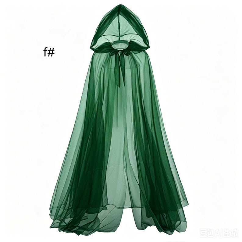 Puede incluir: Una capa con capucha de color verde oscuro transparente hecha de tela de tul ligera. La prenda presenta una capucha puntiaguda y un cierre de lazo a juego en el cuello. El texto f# es visible en la parte superior izquierda de la imagen.