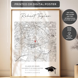 Puede incluir: Un póster rectangular vertical en un marco dorado fino que muestra un mapa de calles en blanco y negro con un marcador de ubicación rojo. El texto dice Robert Taylor, Class of 2025, University of Manchester, B.A. in Economics, y las coordenadas 53.4593 N -2.2335 W, junto a un icono de birrete negro.