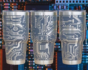 May include: Three stainless steel tumblers with a silver circuit board design on a gray background. The tumblers are labeled "YETI" and "JC".