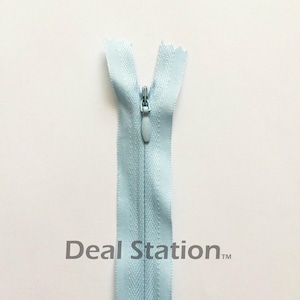 K&ouml;nnte beinhalten: Hellblauer Rei&szlig;verschluss mit passendem Zipper vor wei&szlig;em Hintergrund. Der Rei&szlig;verschluss ist ge&ouml;ffnet und zeigt die Z&auml;hne. Der Text "Deal Station" ist unten aufgedruckt.