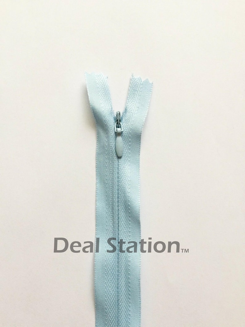 K&ouml;nnte beinhalten: Hellblauer Rei&szlig;verschluss mit passendem Zipper vor wei&szlig;em Hintergrund. Der Rei&szlig;verschluss ist ge&ouml;ffnet und zeigt die Z&auml;hne. Der Text "Deal Station" ist unten aufgedruckt.