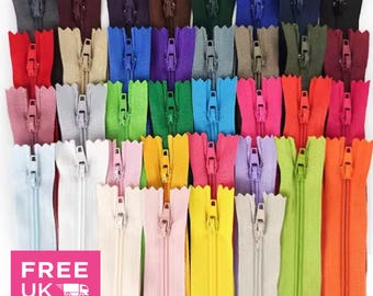 Könnte beinhalten: Eine Sammlung farbenfroher Reißverschlüsse in verschiedenen Farbtönen, darunter Rot, Blau, Grün und Gelb. Die Reißverschlüsse sind in Reihen angeordnet, wobei die Reißverschlussanhänger sichtbar sind. Das Bild enthält auch den Text "Deal-Station".