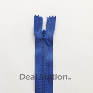 K&ouml;nnte beinhalten: Blauer Rei&szlig;verschluss mit geschlossenem Rei&szlig;verschluss. Der Rei&szlig;verschluss hat einen leuchtenden Blauton und eine strukturierte Optik. Der Text "Deal Station" ist auf dem Rei&szlig;verschluss aufgedruckt.