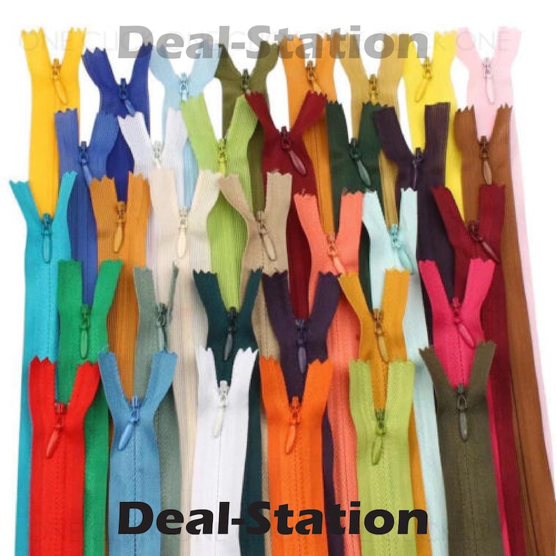K&ouml;nnte beinhalten: Eine Sammlung farbenfroher Rei&szlig;verschl&uuml;sse in verschiedenen Farbt&ouml;nen, darunter Rot, Blau, Gr&uuml;n und Gelb. Der Text "Deal-Station" ist in Wei&szlig; zu sehen. Diese Rei&szlig;verschl&uuml;sse sind wahrscheinlich f&uuml;r N&auml;h- oder Bastelprojekte gedacht.