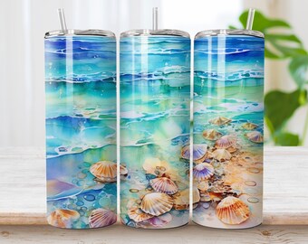 May include: Three cylindrical tumblers with clear lids and straws, featuring a wrap-around watercolor print of ocean waves crashing onto a sandy shore with scattered seashells in shades of blue, turquoise, white, and tan.