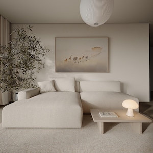 May include: A modern living room with a cream-colored sectional sofa, a light wood coffee table, and a small mushroom-shaped lamp. A framed artwork depicts animals walking towards a boat. A large, round pendant light hangs from the ceiling.