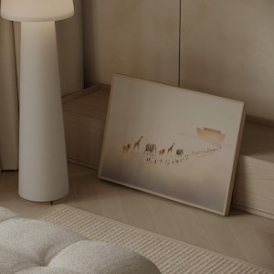 May include: A framed art print depicts a procession of animals, including lions, giraffes, and elephants, walking towards a boat. The artwork has a soft, muted color palette with a light brown wooden frame.