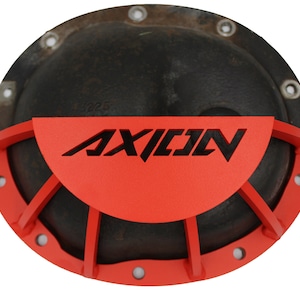 Op de afbeelding: Rode metalen differentieelkap met een zwart AXIO-logo en een beschermende kooi. De kap is ontworpen om het differentieel te beschermen tegen schade.