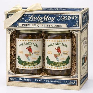 May include: A gift box containing two jars of "Lady May" candied jalapeños. Each jar has a vintage label with a pin-up girl illustration and reads "24 oz." The box is decorated with a cream-colored bow and the words "Premium Quality Goods."