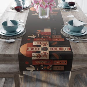 May include: A dark brown table runner with a Southwestern geometric design. The runner features a large cross-like pattern with various geometric shapes in shades of red, orange, and beige. The table is set with plates, bowls, silverware, and wine glasses.
