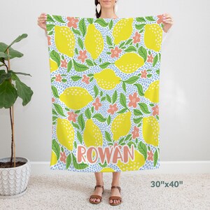 Könnte beinhalten: Ein weißer Duschvorhang aus Stoff mit einem Zitronen- und Blumenmuster. Der Text "ROWAN" ist in hellrosa gedruckt. Der Duschvorhang misst 76 cm x 102 cm.