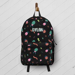 May include: Black backpack with a colorful bug pattern and the name "DYLAN" in white text.