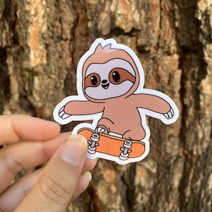 May include: A brown sloth cartoon sticker with a happy expression, riding a skateboard with orange wheels. The sticker is on a brown tree bark background.
