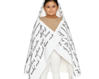May include: A white hooded towel with black text printed on it. The text includes words such as "cover-ups", "unscreen", "chair", "sandcastle", "badminton", "surf", "teard", "bougie", "beary", "snorkel", "scuba", "shore", "coast", "wave", "fuck", "conch", "sand", "far", "tig", "sungponit", "bikini", "tor", "taffy", "driy", "wer-ups", "sun", "ach", "chair", "screen".