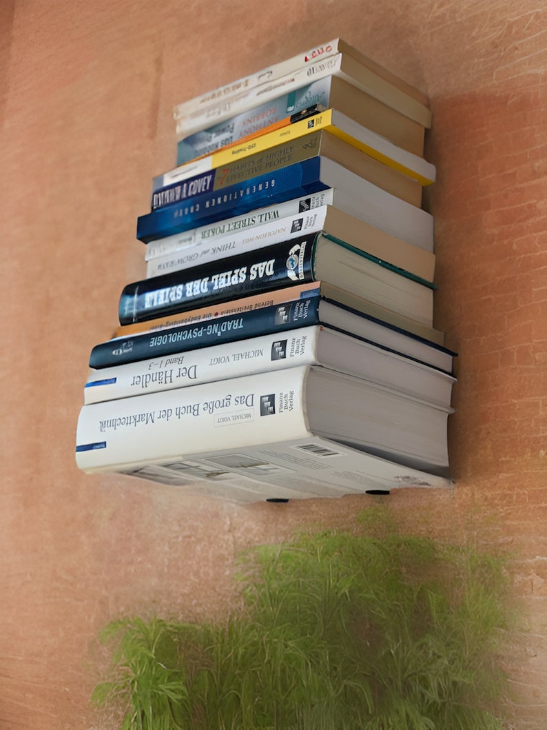 Op de afbeelding: Een stapel boeken op een plank, met titels zoals "Trading-Psychologie", "Das Spiel der Spiel", "Think and Grow Rich" en "Generations of Capital".