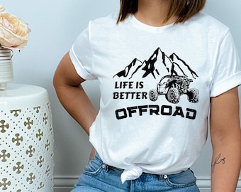 May include: White t-shirt with a black graphic of a mountain range and an off-road vehicle. The text "Life is Better Offroad" is printed below the graphic.