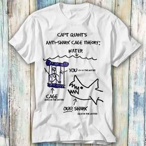 Könnte beinhalten: Weißes T-Shirt mit einer schwarzen und blauen Illustration einer Hai-Käfig-Theorie. Der Text lautet "CAPT QUINT'S ANTI-SHARK CAGE THEORY: WATER YOU GO IN THE WATER CAGE GOES IN THE WATER OUR SHARK ALSO IN THE WATER"
