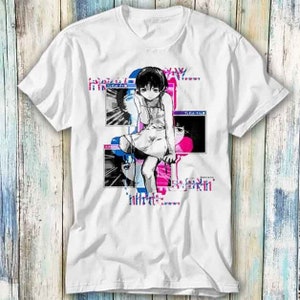 May include: White t-shirt with a graphic print of a girl with short black hair in a white dress. The graphic is in a pixelated style with pink and blue accents. The text "Say" is printed on the shirt.