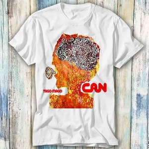 May include: White t-shirt featuring a colourful graphic print of a head with the text "Tago Mago" and "CAN" in red.