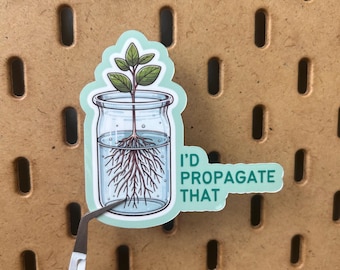 May include: A sticker featuring a plant in a jar with the text "I'd Propagate That." The illustration shows a plant with roots in water. The sticker is being held by tweezers against a brown pegboard background.