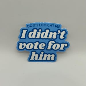 May include: A blue sticker with white text that reads "Don't look at me I didn't vote for him".