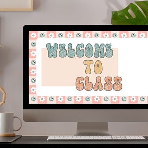 May include: A computer monitor displays a digital image with the words "WELCOME TO CLASS" in a retro font. The design features a pink and white checkered border with smiley faces and flowers. The screen is set on a black desk with a white mug and wooden artist's mannequin.