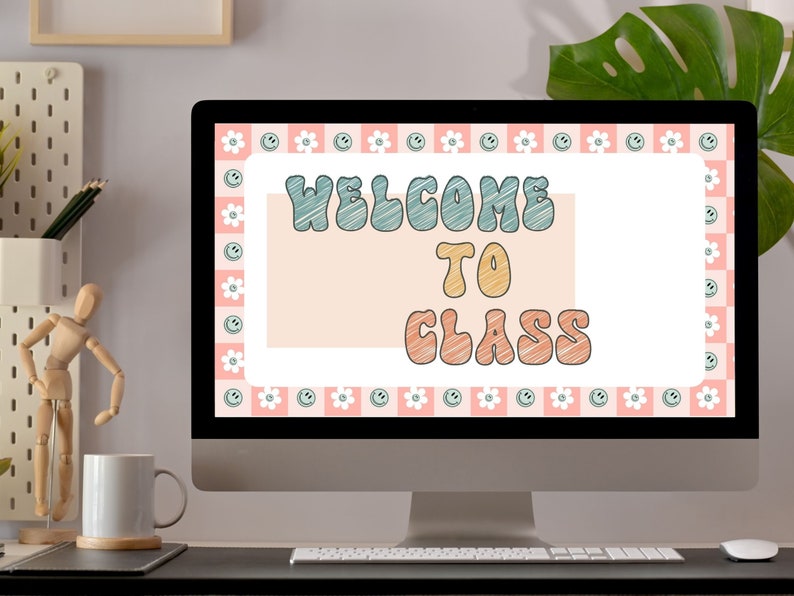 May include: A computer monitor displays a digital image with the words "WELCOME TO CLASS" in a retro font. The design features a pink and white checkered border with smiley faces and flowers. The screen is set on a black desk with a white mug and wooden artist's mannequin.