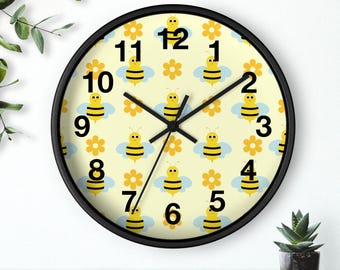 May include: A black framed wall clock with a yellow background and a repeating pattern of cartoon bees and flowers. The clock face has black numbers and hands.