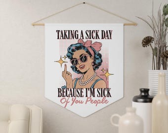 May include: A white banner with a pop art style illustration of a woman wearing sunglasses and a pink bow. The text on the banner reads "Taking a sick day because I'm sick of you people."