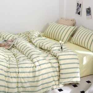 Puede incluir: Un juego de cama a rayas blancas y verdes con una funda n&oacute;rdica, dos fundas de almohada y una s&aacute;bana bajera. La ropa de cama est&aacute; hecha de tela suave y c&oacute;moda y presenta un patr&oacute;n de rayas sutil.