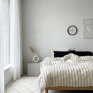 Striped bedding set styled in cozy apartment bedroom makeover