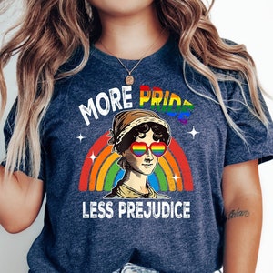 May include: A navy blue t-shirt with a rainbow and the text "More Pride Less Prejudice". The rainbow has a woman's face with rainbow sunglasses in the center.