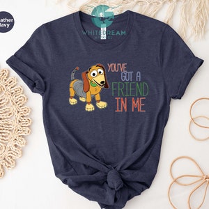 Op de afbeelding: Een marineblauw t-shirt met een cartoon afbeelding van een hond met de tekst "You've got a friend in me".