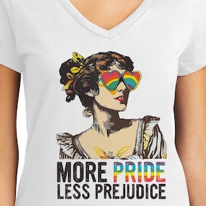 May include: White v-neck t-shirt with a vintage illustration of a woman wearing rainbow heart-shaped sunglasses. The text "More Pride Less Prejudice" is printed below the illustration.