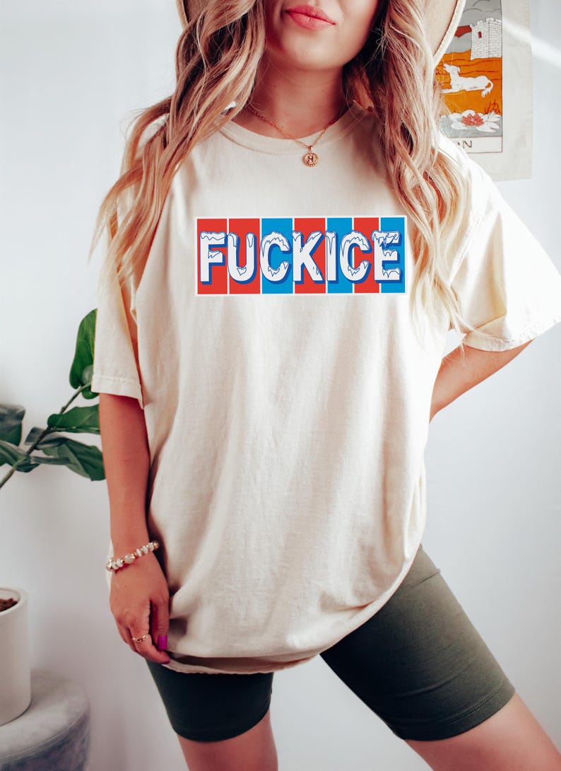 以下が含まれることがあります： 赤、白、青のブロックデザインで「FUCKICE」という言葉が入ったクリーム色のTシャツ。Tシャツは半袖でゆったりとしたフィット感です。テキストは胸の中央に配置されています。